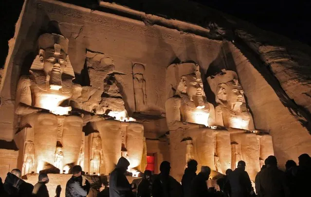 Visitors gather before sunrise outside Ramses II's (1279-1213 BC) Great Temple in Egypt's southern town of Abu Simbel ahead of the solar alignment early on February 22, 2022. The sun illuminates the temple's inner sanctuary only twice a year with a wide belief among archaeologists that the two days mark the pharaoh's birthday and day of coronation. The temple, constructed circa 1264 BC, was cut out of sandstone cliffs above the Nile River in an area near the second cataract. It was saved from the rising waters of Lake Nasser created by the construction of the Aswan High Dam in the 1960s by an international campaign led by UNESCO to move the temple to higher ground. (Photo by Mohamed Asad/AFP Photo)