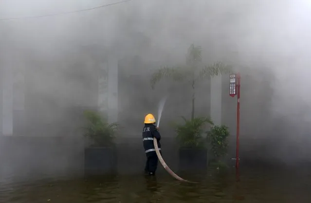 A firefighter tries to extinguish a fire at a multi-storey shopping complex in Mumbai, India, July 21, 2015. (Photo by Danish Siddiqui/Reuters)