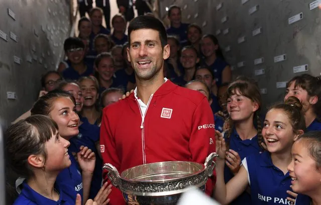 Serbia's Novak Djokovic is cheered by ball girls after defeating Britain's Andy Murray in their final match of the French Open tennis tournament at the Roland Garros stadium, Sunday, June 5, 2016 in Paris. (Photo by Nicolas Gouhier, Pool via AP Photo)