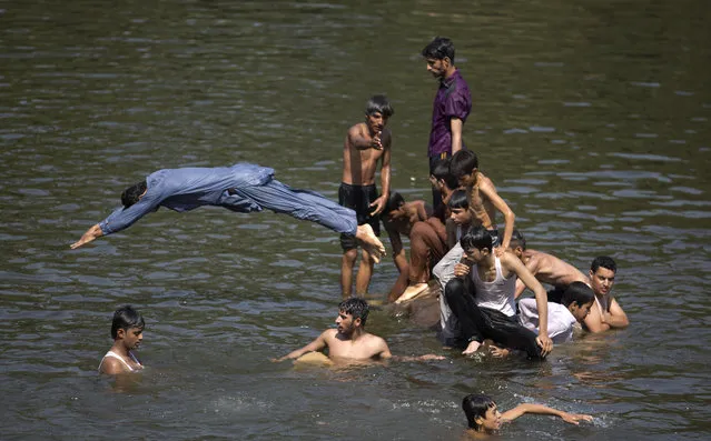 People cool themselves in a stream to beat the heat as temperatures reached 38 Celsius (100F) during the Muslim holy fasting month of Ramadan, Monday, May 29, 2017, in Islamabad, Pakistan. (Photo by B.K. Bangash/AP Photo)