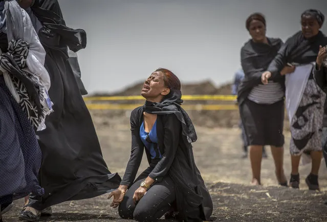Ethiopian relatives of crash victims mourn and grieve at the scene where the Ethiopian Airlines Boeing 737 Max 8 crashed shortly after takeoff on Sunday killing all 157 on board, near Bishoftu, south-east of Addis Ababa, in Ethiopia Thursday, March 14, 2019. The French air accident investigation authority said Thursday that it will handle the analysis of the black boxes retrieved from the crash site and they have already arrived in France but gave no time frame on how long the analysis could take. (Photo by Mulugeta Ayene/AP Photo)