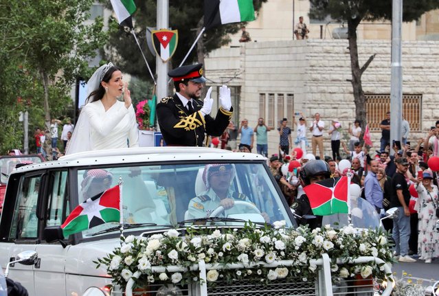 Jordan's Crown Prince Hussein and Saudi Arabian architect Rajwa Al-Saif greet people during the motorcade procession after a wedding ceremony in Amman, Jordan, on June 1, 2023. Jordan's Crown Prince Hussein married Saudi Arabian architect Rajwa Al-Saif on Thursday during a lavish wedding ceremony attended by Arab and foreign dignitaries, the Royal Hashemite Court announced. (Photo by Ahmad Abdo/Reuters)