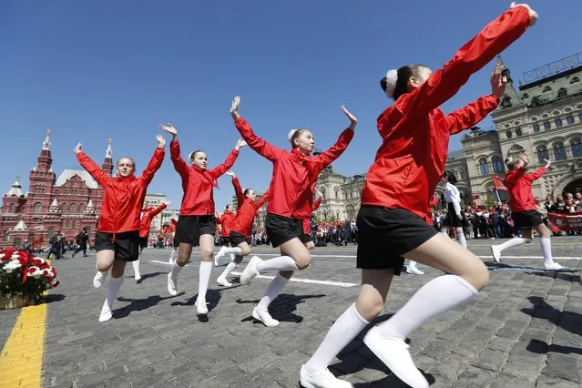 Girls in red neckerchiefs dance on Red Square, with the GUM, the State Department Store and the Historical Museum in the background, during a ceremony to celebrate joining the Pioneers organization and 100th anniversary of the All-Union Pioneer Organization, in Moscow, Russia, Sunday, May 22, 2022. Pro-Communist Russians are trying to preserve the Young Pioneers, which used to be the Communist league for pre-teens in the Soviet Union. (Photo by AP Photo/Stringer)
