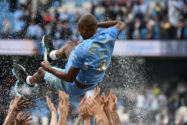 Manchester City's Brazilian midfielder Fernandinho is thrown in the air by his teammates as City players celebrate on the pitch after the English Premier League football match between Manchester City and Aston Villa at the Etihad Stadium in Manchester, north west England, on May 22, 2022. Manchester City won the Premier League for the fourth time in five seasons after a pulsating title race reached a dramatic conclusion as the champions staged an incredible comeback from two goals down to beat Aston Villa 3-2 on Sunday. (Photo by Oli Scarff/AFP Photo)