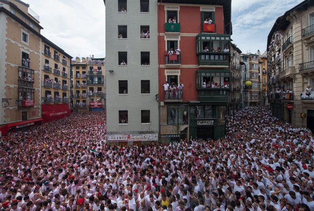 Participants celebrate the “Chupinazo” (start rocket) to mark the kickoff at noon sharp of the San Fermin Festival, in front of the Town Hall of Pamplona, northern Spain, on July 6, 2017. (Photo by Miguel Riopa/AFP Photo)
