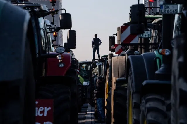 A man stands on a tractor as thousands of German farmers demonstrate along the 17 Juni street in Berlin, Germany, 17 January 2020. Some 5,000 farmers and their tractors gathered in the German capital to protest a series of measures taken against the agricultural community, from climate laws to the recent agrarian package. (Photo by Filip Singer/EPA/EFE)