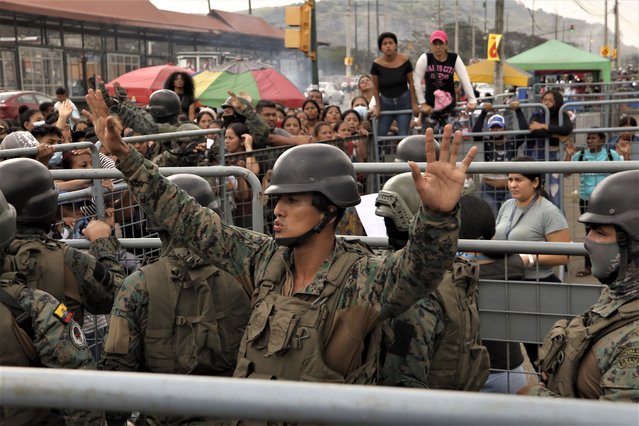 A soldier asks for calm from the friends and family members of inmates seeking information after deadly clashes at the Litoral Penitentiary, in Guayaquil, Ecuador, Tuesday, July 25, 2023. (Photo by Cesar Munoz/AP Photo)