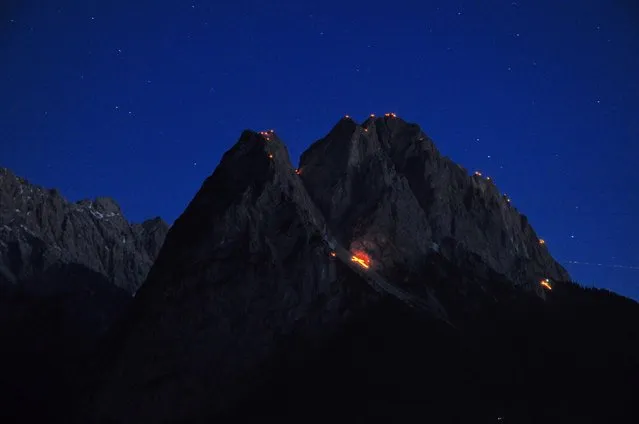 Midsummer bonfires seen on the Waxenstein mountain in the Zugspitze mountain massif near Garmisch-Partenkirchen, Germany, early 24 June 2016. St. John's fires and mountain bonfires are traditionally ignited in the German state Bavaria for summer solstice. (Photo by Peter Lehner/EPA)