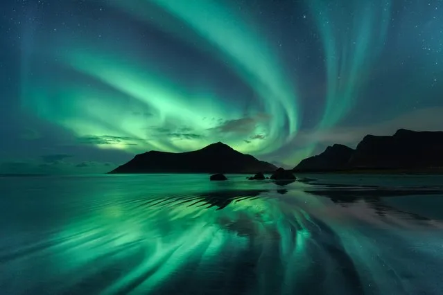 “Reflection”, Beate Behnke (Germany). The reflection in the wave ripples of Skagsanden beach mirrors the brilliant green whirls of the Aurora Borealis in the night sky overhead. To obtain the effect of the shiny surface, the photographer had to stand in the wave zone of the incoming tide, and only when the water receded very low did the opportunity to capture the beautiful scene occur. (Photo by Beate Behnke/National Maritime Museum/The Guardian)