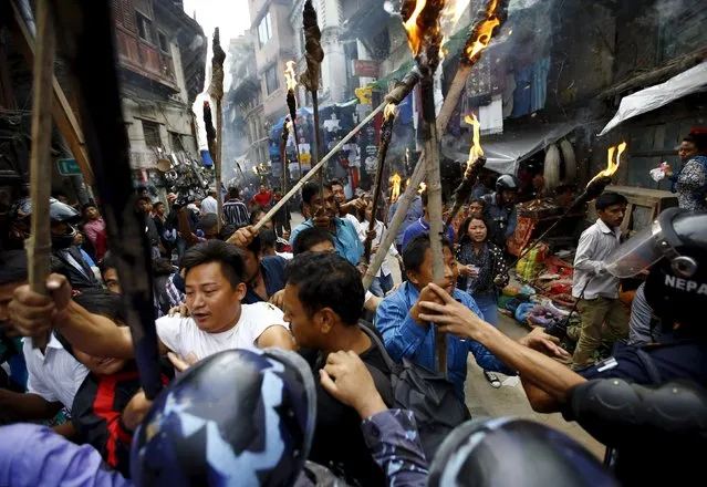 Protesters chanting slogans break through a police line blocking them during a rally organised by the 30-party alliance led by a hardline faction of former Maoist rebels, who are protesting against the draft of the new constitution, in Kathmandu August 15, 2015. (Photo by Navesh Chitrakar/Reuters)