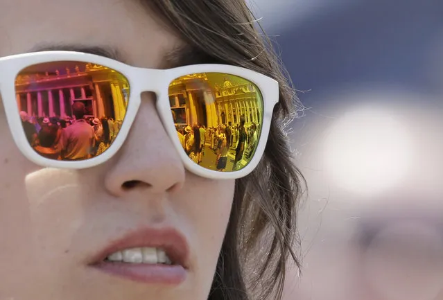 The St. Peter's Square is reflected on the sunglasses of a woman during the Angelus noon prayer delivered by Pope Francis from his studio's window at the Vatican, Sunday, July 19, 2015. (Photo by Gregorio Borgia/AP Photo)