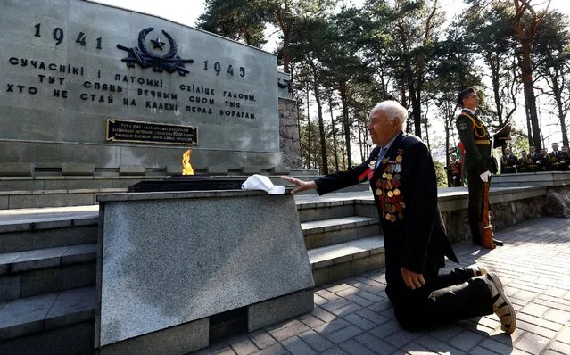 Stanislav Shantor, 90, World War II veteran, knees at the memorial during the reburial of the remains of 147 Soviet prisoners of war, before the celebration of Independence Day, which is marked on Sunday, in Minsk, Belarus, July 1, 2016. (Photo by Vasily Fedosenko/Reuters)