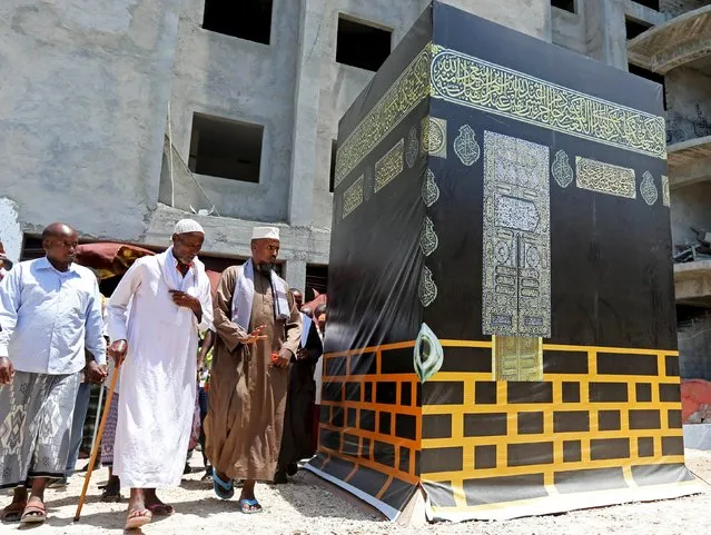 Somali people circle a model of al-Hajr-Aswad, or the Black Stone, as they go through a mock haj pilgrimage ritual, in preparation of their pilgrimage to the holy city of Mecca, expected to take place late September 2015, in capital Mogadishu August 19, 2015. (Photo by Feisal Omar/Reuters)