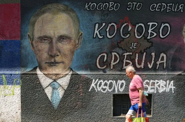 A man passes by graffiti depicting Russian President Vladimir Putin, reading: “Kosovo is Serbia” in Belgrade, Serbia, Monday, August 1, 2022. Kosovo's authorities early Monday moved to ease mounting ethnic tensions in the country by delaying a controversial order on vehicle license plates and identity cards that triggered riots by minority Serbs who put up roadblocks, sounded air raid sirens and fired their guns into the air. (Photo by Darko Vojinovic/AP Photo)