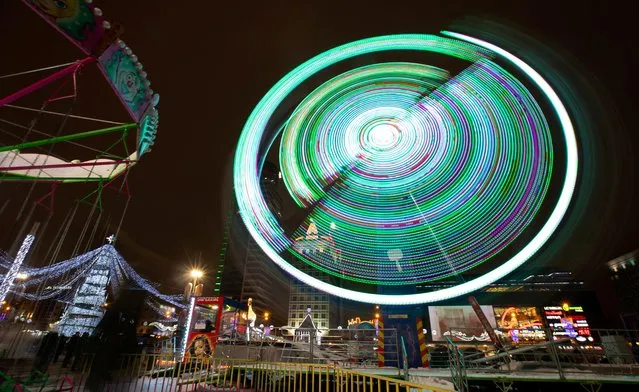 People enjoy Sunday evening on a carousel in the centre of Minsk, Belarus December 29, 2019. (Photo by Vasily Fedosenko/Reuters)