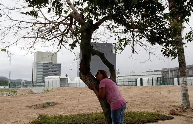 Marcia Lemos, 58, who has lived in the Vila Autodromo slum for 13 years, hugs a tree at the site of her former house during a visit to the community in Rio de Janeiro, Brazil, July 28, 2016. Picture taken July 28, 2016. (Photo by Ricardo Moraes/Reuters)