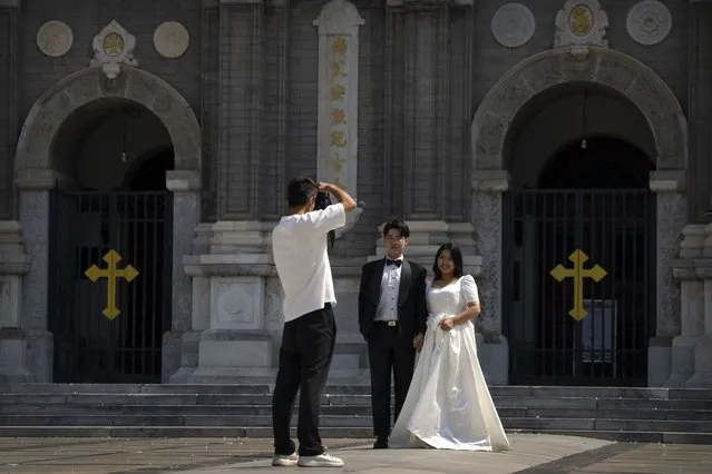 A couple poses for photos in front of the Wangfujing Church, a Catholic church in Beijing, Wednesday, September 14, 2022. (Photo by Mark Schiefelbein/AP Photo)