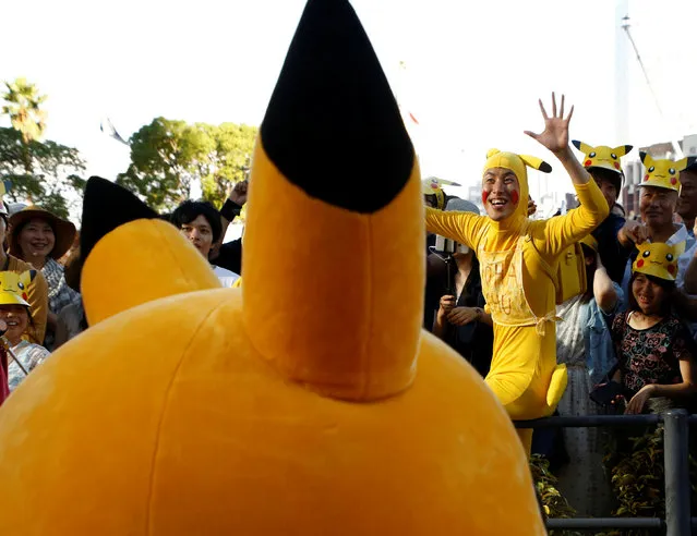 A man wearing a costume of Pokemon's character Pikachu reacts to performers during a parade in Yokohama, Japan, August 7, 2016. (Photo by Kim Kyung-Hoon/Reuters)
