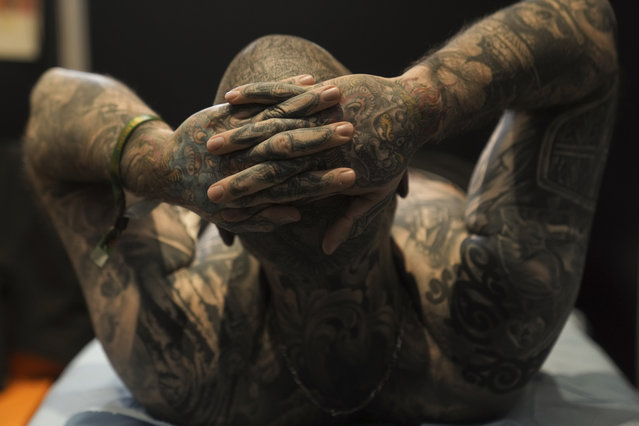 A man lies on a bed as he waits for ink to dry during a tattoo convention, in Paris, Saturday, February 1, 2025. (Phoot by Thibault Camus/AP Photo)