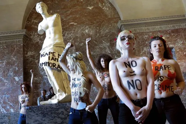 Topless activists of the Ukrainian women movement Femen protest against anti women's politic in front of the Venus de Milo statuewhere they hung a banner, at the Louvre Museum on October 3, 2012 in Paris. AFP PHOTO LIONEL BONAVENTURE  (Photo credit should read LIONEL BONAVENTURE/AFP)