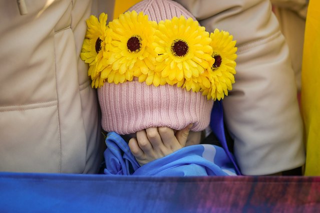 Daria, 4 years-old, covers her face as members of the Ukrainian community stage an event to mark three years since the start of Russia's invasion of Ukraine in Bucharest, Romania, Sunday, February 23, 2025. (Photo by Andreea Alexandru/AP Photo)