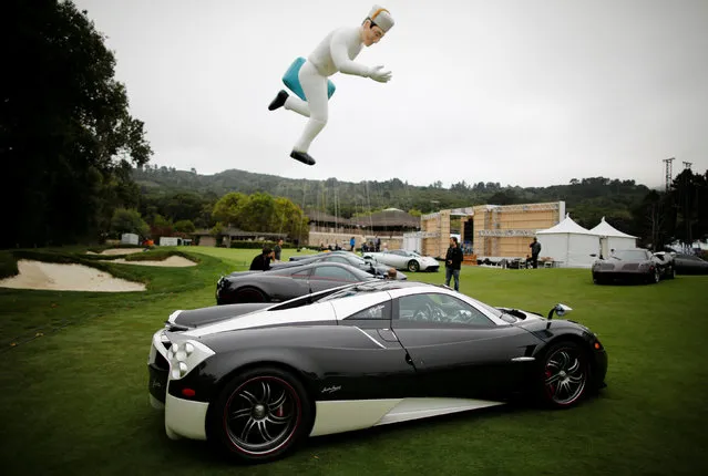 The Peninsula Hotels mascot floats above Pagani supercars during The Quail, A Motorsports Gathering, in Carmel, California, U.S. August 19, 2016. (Photo by Michael Fiala/Reuters/Courtesy of The Revs Institute)