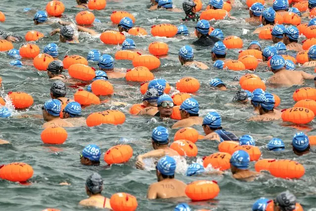 Swimmers compete in the annual harbor race at the Victoria Harbor in Hong Kong, Sunday, October 23, 2022. Thousands of swimmers took part in the Hong Kong's iconic race swimming across the harbor from Hong Kong Island to Kowloon Peninsula. (Photo by Anthony Kwan/AP Photo)