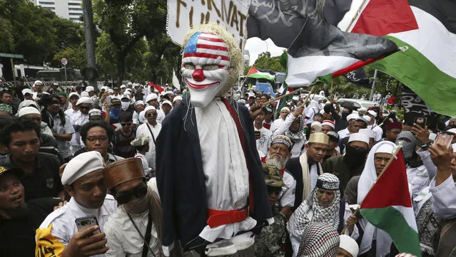 Protesters carry a representation an effigy of U.S. President Donald Trump during a rally outside the U.S. Embassy in Jakarta, Indonesia, Monday, December 11, 2017. Hundreds of people staged the protest in the Indonesian capital of Jakarta to denounce Trump's decision to recognize Jerusalem as Israel's capital. (Photo by Achmad Ibrahim/AP Photo)