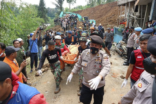 Rescuers carry the body of a victim recovered from under the rubble at a village affected by an earthquake-triggered landslide in Cianjur, West Java, Indonesia, Tuesday, November 22, 2022. The earthquake has toppled buildings on Indonesia's densely populated main island, killing a number of people and injuring hundreds. (Photo by Rangga Firmansyah/AP Photo)