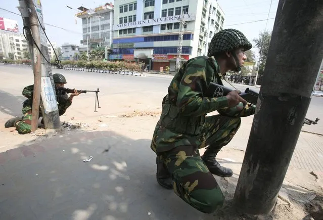 In this February 25, 2009 file photo, Bangladesh army soldiers take positions near the headquarters of Bangladesh Rifles in Dhaka. In 2013, a trial court sentenced 152 people to death, but in response to an appeal, the High Court commuted the sentences for eight of them to life in prison and acquitted four others. Another man died during the 370 days of proceedings before Monday's verdict. A total of 846 people, mostly border guards, are facing trial. (Photo by Pavel Rahman/AP Photo)