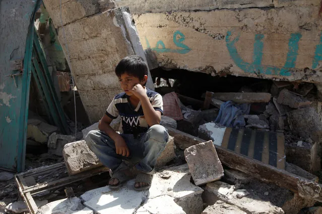 A boy sits on rubble outside a house destroyed by a Saudi-led airstrike in Yemen's capital Sanaa September 4, 2016. (Photo by Mohamed al-Sayaghi/Reuters)