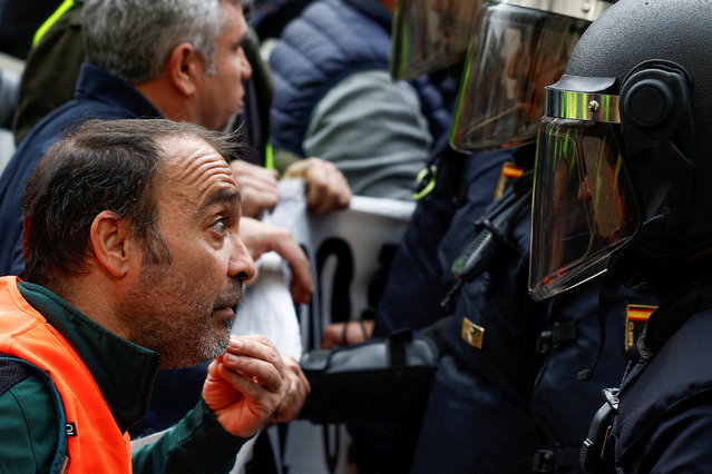 A protester confronts a police member as Spanish farmers protest over price pressures, taxes and green regulation, grievances shared by farmers across Europe, in Madrid, Spain, on February 21, 2024. (Photo by Juan Medina/Reuters)