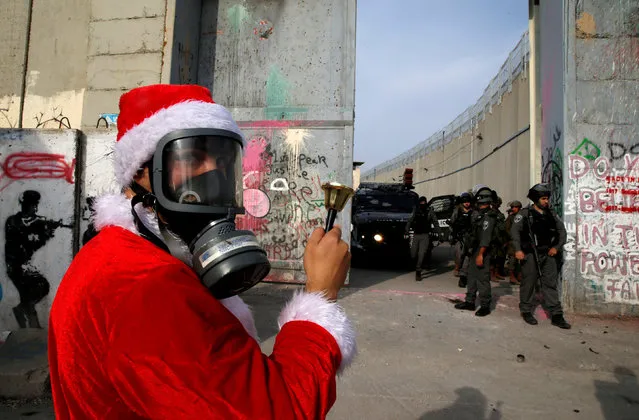 A Palestinian dressed as Santa Claus stands in front of Israeli troops during a protest in the West Bank city of Bethlehem, December 23, 2017. (Photo by Ammar Awad/Reuters)