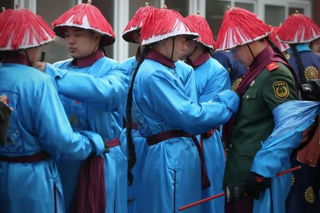 Chinese paramilitary police officers dressed as Qing Dynasty servants before a re-enactment of an ancient ceremony of Qing Dynasty emperors praying for good harvest and fortune during the opening ceremony of the Spring Festival Temple Fair at the Temple of Earth park on February 9, 2013 in Beijing, China. The Chinese Lunar New Year of Snake also known as the Spring Festival, which is based on the Lunisolar Chinese calendar, is celebrated from the first day of the first month of the lunar year and ends with Lantern Festival on the Fifteenth day.  (Photo by Feng Li)