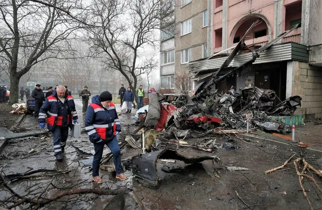 Rescue services and medical workers at the scene of a helicopter crash near the wreckage in Brovary, near Kyiv, Ukraine, 18 January 2023. At least 18 people died, including three children, after a helicopter crashed near a kindergarten and a residential building in the city of Brovary, Oleksiy Kuleba, the head of Kyiv Regional Military Administration wrote on telegram. “Among them are Minister of Internal Affairs of Ukraine Denys Monastyrskyi, his first deputy Yevhen Yenin, State Secretary of the Ministry of Internal Affairs Yuri Lubkovych, their assistants and the helicopter crew”, stated President of Ukraine Volodymyr Zelensky. (Photo by Sergey Dolzhenko/EPA/EFE/Rex Features/Shutterstock)
