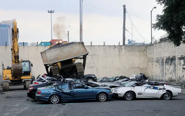 A bulldozer destroys condemned smuggled luxury cars worth 61,626,000.00 pesos (approximately US$1.2 million), which include used Lexus, BMW, Mercedes-Benz, Audi, Jaguar and Corvette Stingray, during the 116th Bureau of Customs founding anniversary in Metro Manila, Philippines February 6, 2018. (Photo by Romeo Ranoco/Reuters)