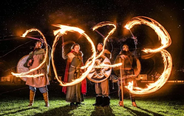 Re-enactors use flaming torches to write 2023 during the Flamborough Fire Festival, a Viking themed parade in aid of charities and local community groups held on New Year’s Eve on December 31, 2022. (Photo by Danny Lawson/PA Wire via Getty Images)