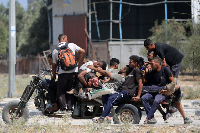 People transport Palestinians who were shot while seeking aid at a US-backed Gaza Humanitarian Foundation distribution point, at the entrance of the Bureij refugee camp in the central Gaza Strip on July 27, 2025. (Photo by Eyad Baba/AFP Photo)