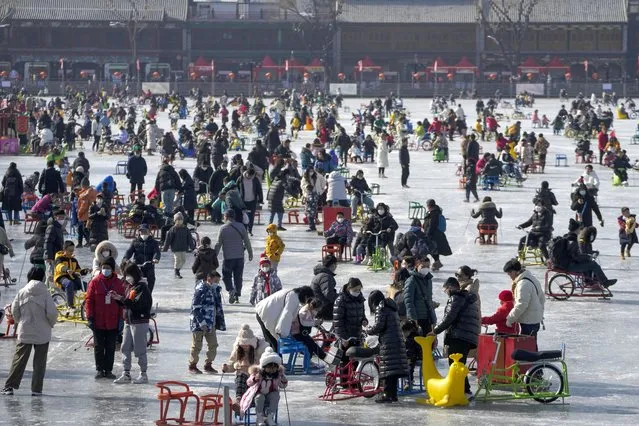Visitors enjoy skating on the crowded frozen Houhai Lake in Beijing, Monday, January 30, 2023. Chinese people are enjoying the Lunar New Year and visiting various tourist sites in cities around China following the lifting last month of draconian COVID-19 restrictions, allowing a return to many aspects of normal life. (Photo by Andy Wong/AP Photo)