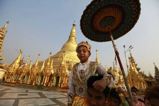 A boy rides on the shoulders his family members as they proceed through the compounds of the Shwedagon Pagoda during their “Shin Phu”, a ceremony to initiate novice monks, in Yangon, Myanmar, on April 3, 2013. (Photo by Soe Zeya Tun/Reuters)