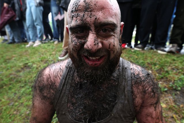 A participant covered in mud reacts as he takes part in the ancient game of Lelo Burti, (Field Ball), in the village of Shukhuti in the Guria region of Georgia on May 5, 2024, during the Orthodox Easter celebrations. The brutal folk game of Lelo Burti has no limit to the number of participants or the match time. Nor is there a referee: none is needed when there are so few rules. It is still played occasionally in rural parts of the country such as the village of Shukhuti in the western region of Guria where the annual match commemorates a battle victory by the Gurians over the Ottomans. (Photo by Giorgi Arjevanidze/AFP Photo)