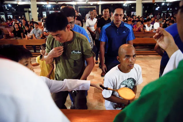 Believers receive communion during a service in a chapel at Camp Crame, the headquarters of Philippine National Police (PNP) in Manila, Philippines October 9, 2016. (Photo by Damir Sagolj/Reuters)