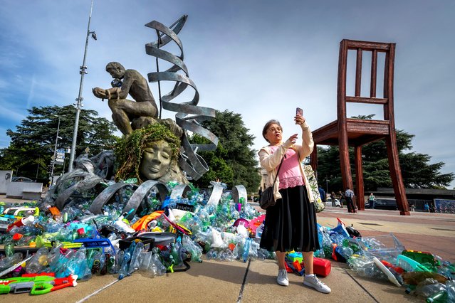 A women takes a selfie in front of the artwork by Canadian artist, activist, and photographer Benjamin Von Wong entitled “The Thinker's Burden” a 6-meter-tall sculptural remix of Rodin's iconic Thinker, which is being created for the Plastics Treaty negotiations, in front of the United Nations Offices in Geneva, on August 4, 2025. Negotiators will take another stab at reaching a global pact on plastic pollution at talks opens from August 5 to 14, 2025 in Geneva but they face deep divisions over how to tackle the health and ecological hazard. (Photo by Fabrice Coffrini/AFP Photo)