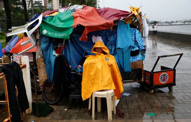 A vendor takes shelter next to his closed shop in Manila as Typhoon Sarika slammed central and northern Philippines, October 16, 2016. (Photo by Erik De Castro/Reuters)