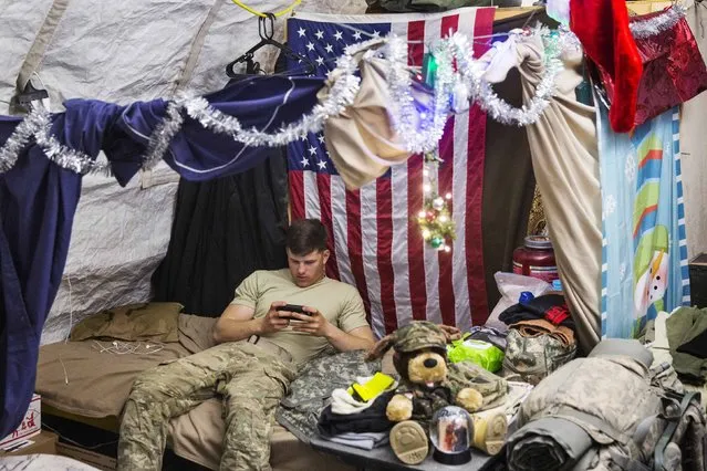 A U.S. soldier from the 3rd Cavalry Regiment relaxes in his quarters after taking part in a mortar exercise on forward operating base Gamberi in the Laghman province of Afghanistan December 24, 2014. (Photo by Lucas Jackson/Reuters)