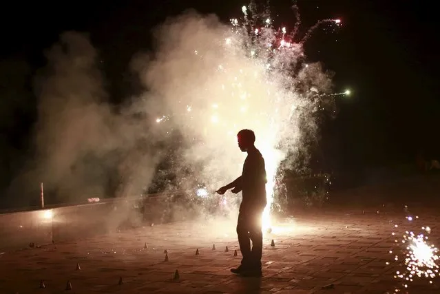 A man lights firecrackers while celebrating the Hindu festival of Diwali, the annual festival of lights in Mumbai, India, November 11, 2015. (Photo by Danish Siddiqui/Reuters)