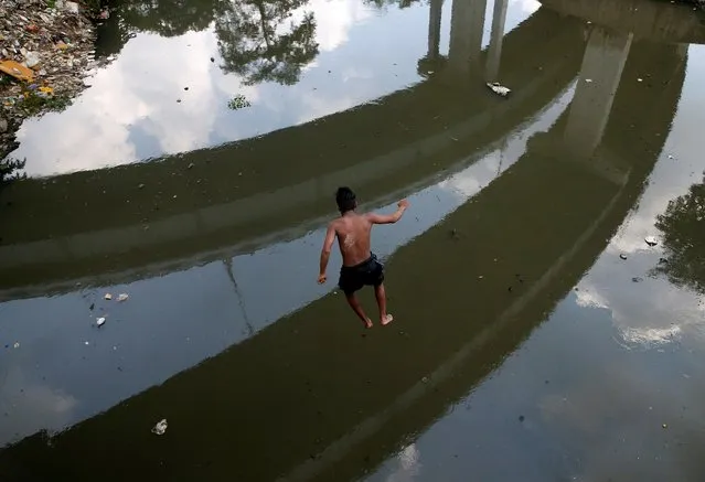 A boy jumps into a polluted canal from a flyover in Kolkata, India, October 16, 2020. (Photo by Rupak De Chowdhuri/Reuters)