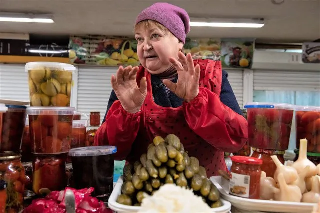 Tetyana Motorna appears at her stall in Volodymirsky market in Kyiv, Ukraine, on February 9, 2023. Motorna, who has sold pickled fruit and vegetables for decades, supports chef Ievgen Klopotenko’s work to secure borsch as a national treasure for Ukraine. (Photo by Chris Warde-Jones/AP Photo)