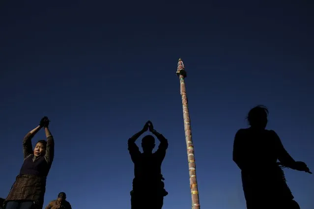 Pilgrims pray outside the Jokhang Temple in central Lhasa, Tibet Autonomous Region, China, as the sun rises November 20, 2015. Every day thousands of Tibetans visit and pray at Jokhang Temple, considered one of the most sacred places of worship. (Photo by Damir Sagolj/Reuters)