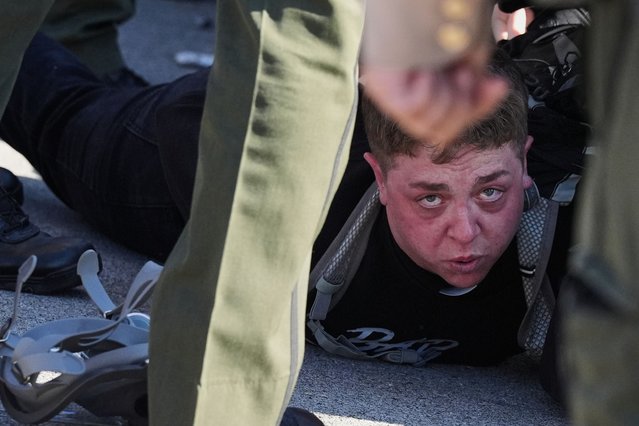 Illinois State police detain a protester outside an ICE processing facility during a protest residents deem a racist and aggressive overreach of the federal government, in Broadview, Ill., November 14, 2025, as an immigration crackdown enters a third month . (Photo by Nam Y. Huh/AP Photo)